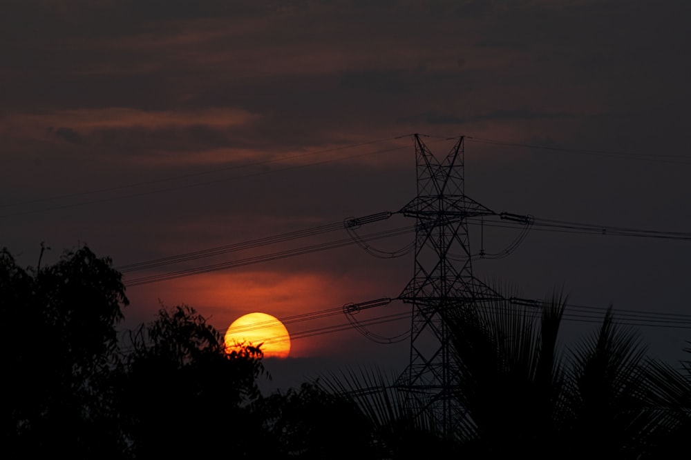 silhouette of electric tower during sunset