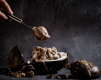 Rich chocolate artisanal ice cream melting slightly in a rustic bowl with chocolate shavings