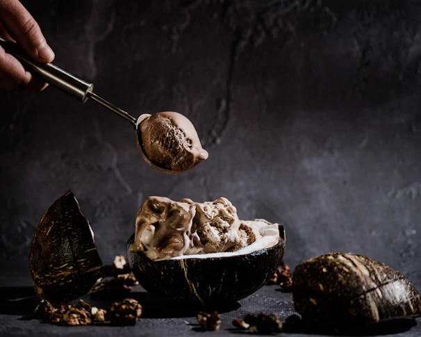 Rich chocolate artisanal ice cream melting slightly in a rustic bowl with chocolate shavings