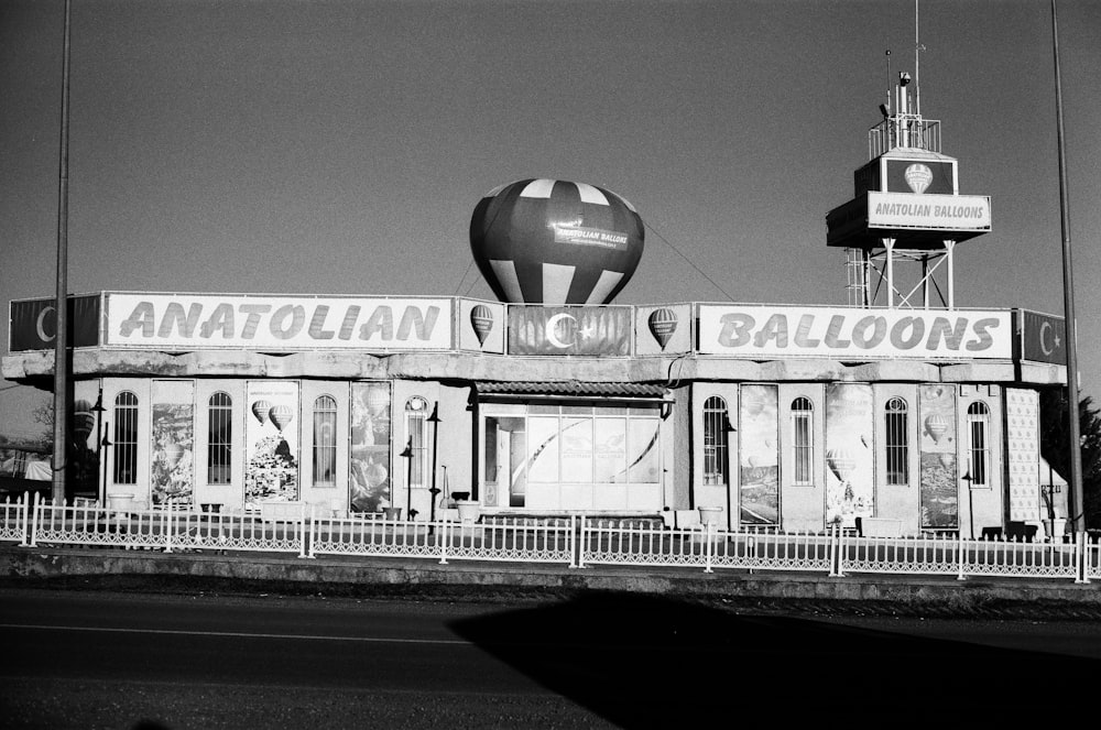 a black and white photo of a building with a hot air balloon on top of
