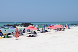 A vibrant beach scene featuring a colorful, sturdy madtre beach umbrella providing shade to a relaxed family.