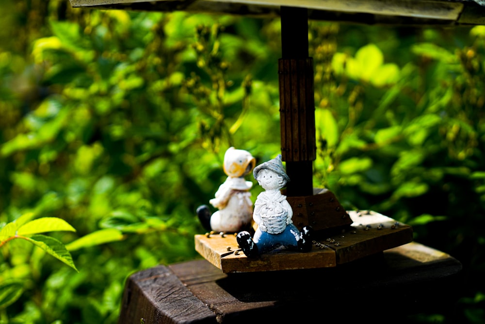 white and blue ceramic angel figurine on brown wooden table