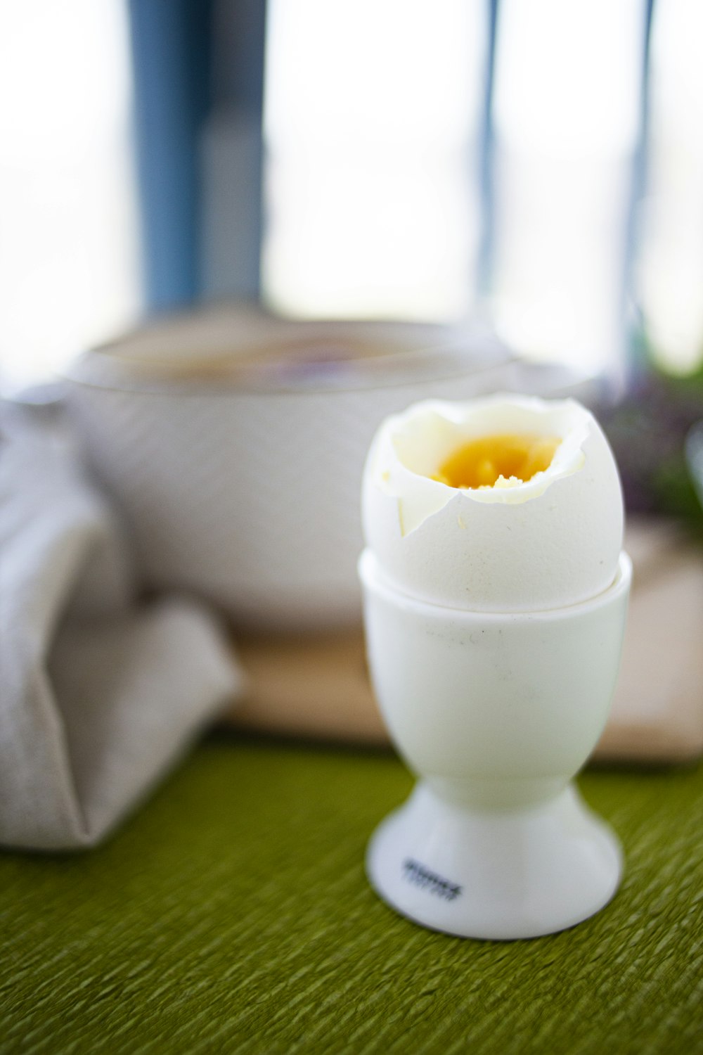 white ceramic egg figurine on green table