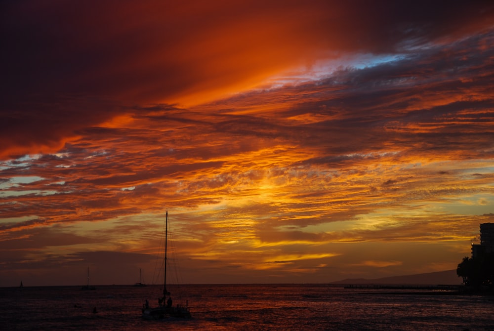 silhouette of boat on sea during sunset