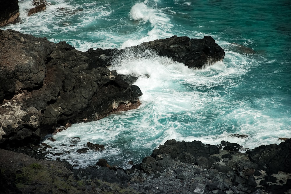 ocean waves crashing on rocky shore during daytime