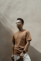 A relaxed model wearing a crisp linen shirt and pants, standing in a sunlit room with soft natural light.