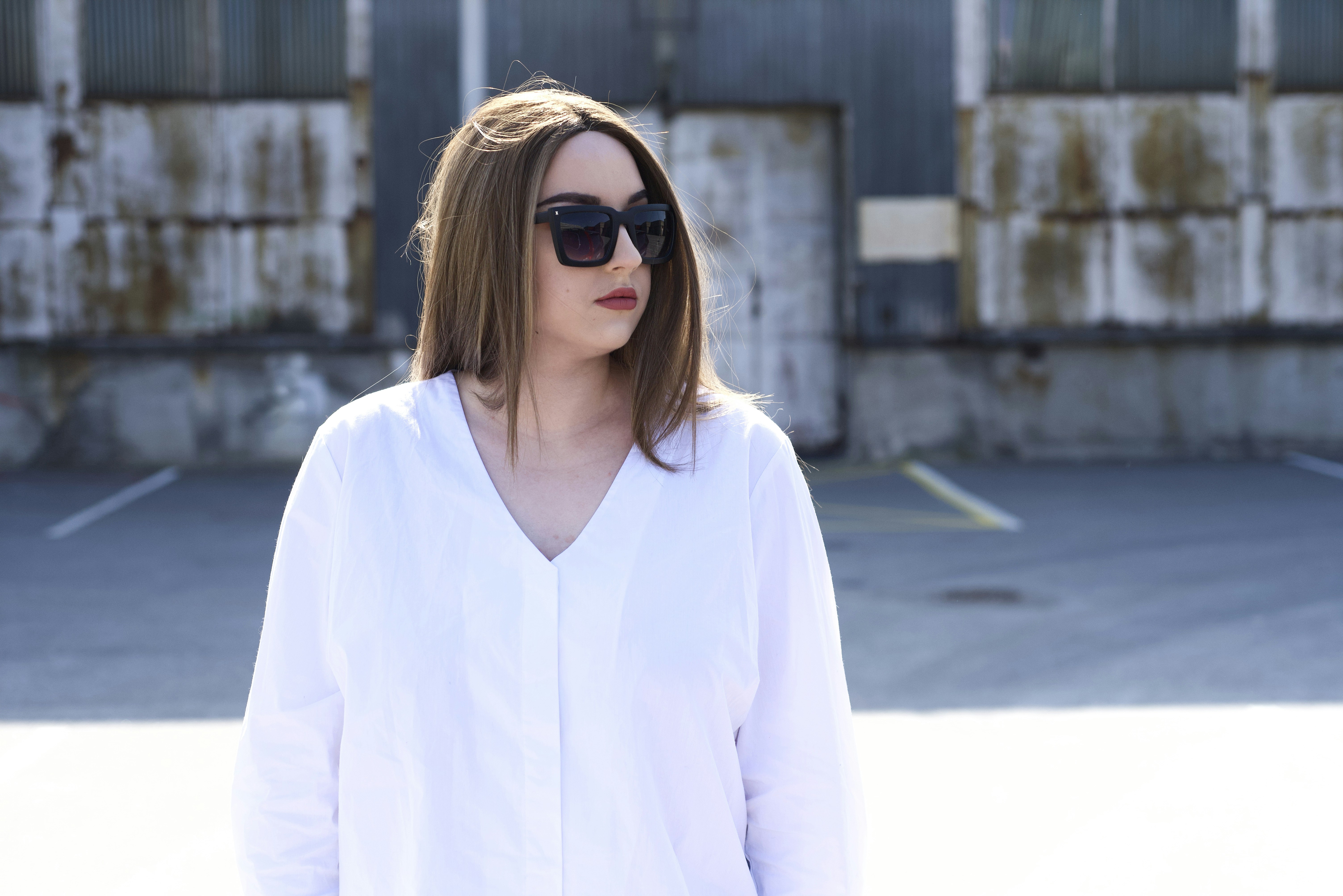 woman in white long sleeve shirt wearing black sunglasses