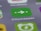 A close-up view of a smartphone screen displaying the Citymapper app icon, which is green with a white arrow and two dots. The background shows blurred app icons in various colors, creating a soft-focus effect.