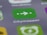 A close-up view of a smartphone screen displaying the Citymapper app icon, which is green with a white arrow and two dots. The background shows blurred app icons in various colors, creating a soft-focus effect.