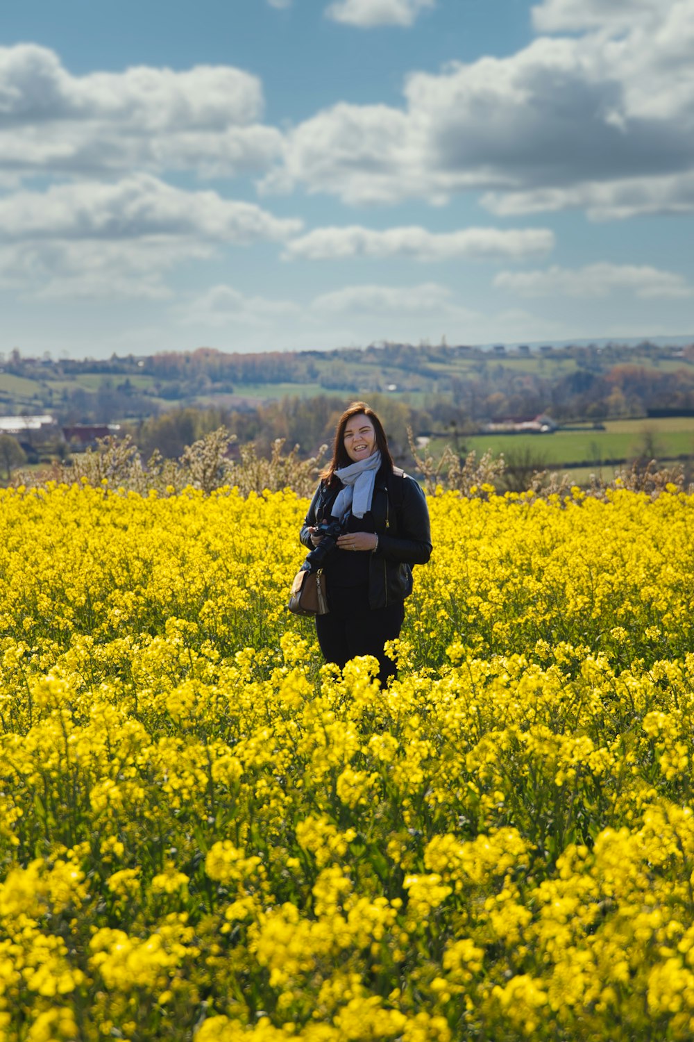 woman in black long sleeve shirt standing on yellow flower field during daytime