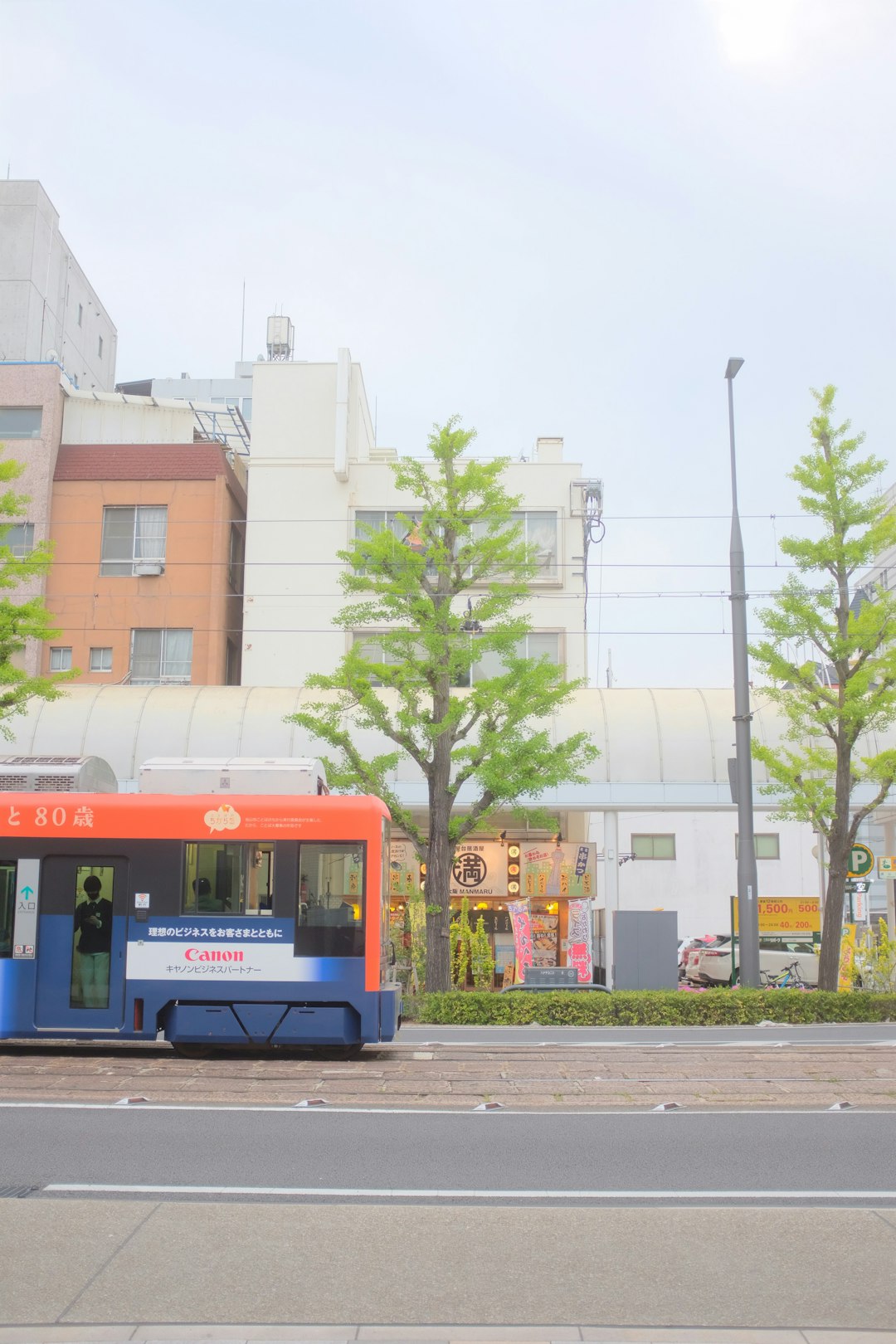 blue and yellow bus on road near white concrete building during daytime