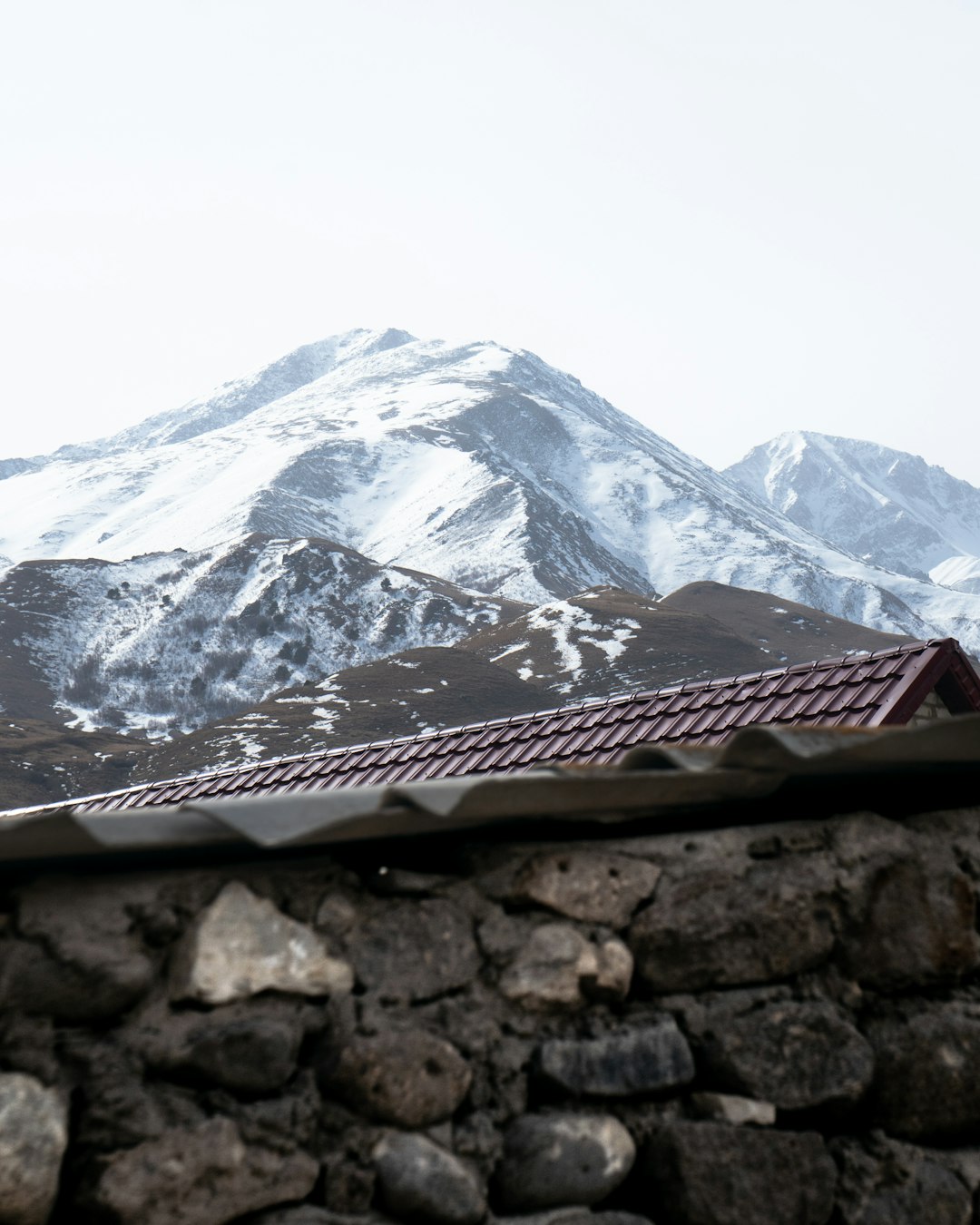 snow covered mountain under white sky during daytime