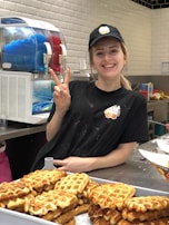 A smiling staff member serving food at the counter.