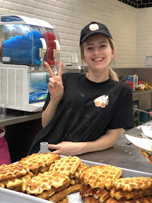 Friendly staff serving a happy customer at the counter.