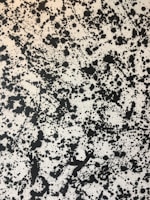 Close-up of a premium black t-shirt featuring a vibrant, abstract ink splash design.