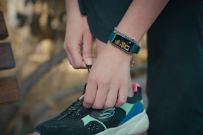 Energetic runner tying shoelaces wearing vibrant fitness gear outdoors.