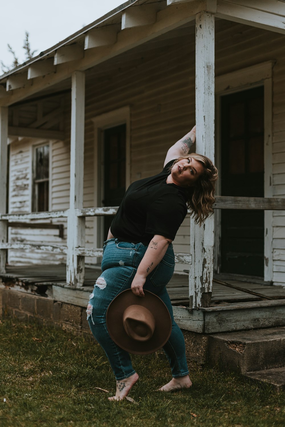 woman in black long sleeve shirt and blue denim jeans sitting on brown wooden bench during