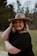 woman in black sleeveless dress wearing brown fedora hat