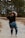 woman in black t-shirt and blue denim jeans standing on dirt road during daytime