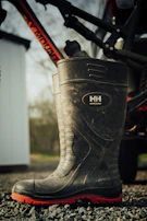 Black leather motorcycle boot with rugged sole on a gravel path