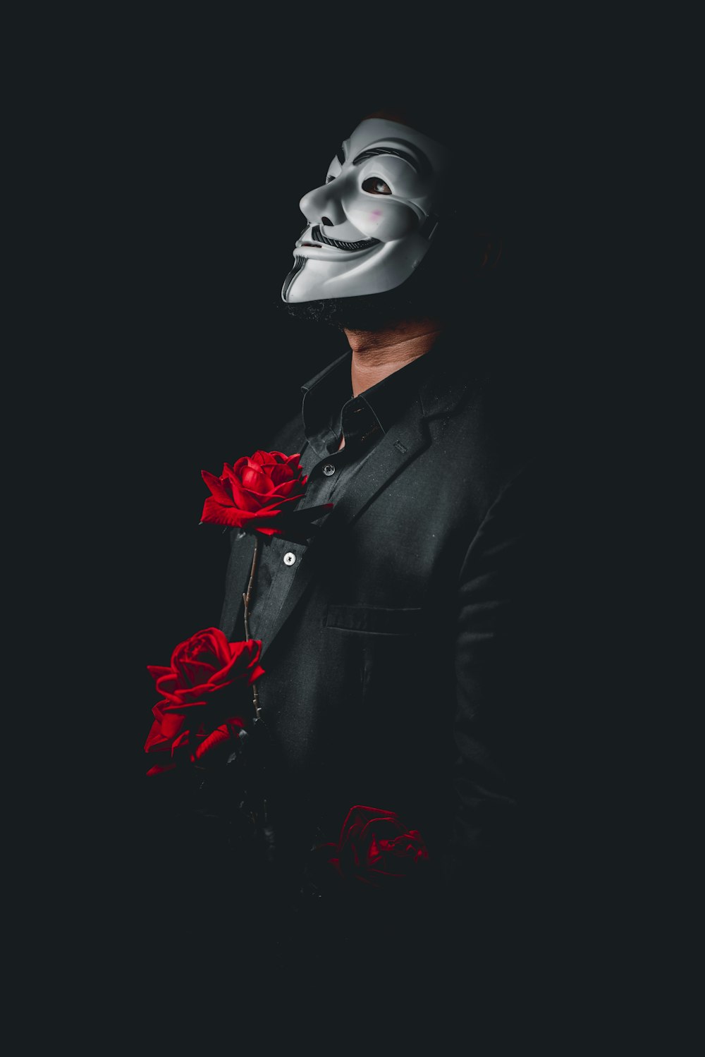 person in black suit with red rose on ear