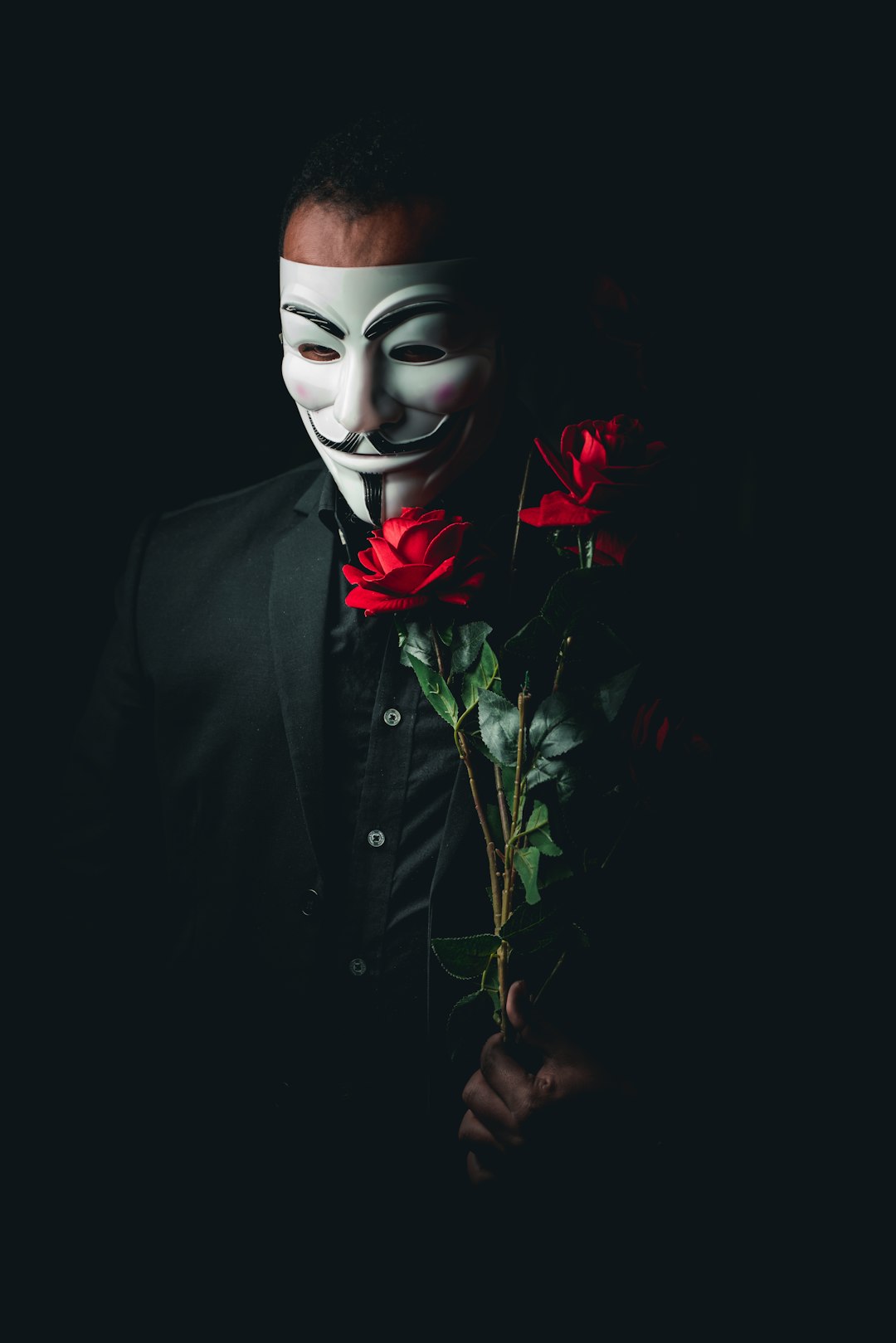 person in black suit with red rose on face