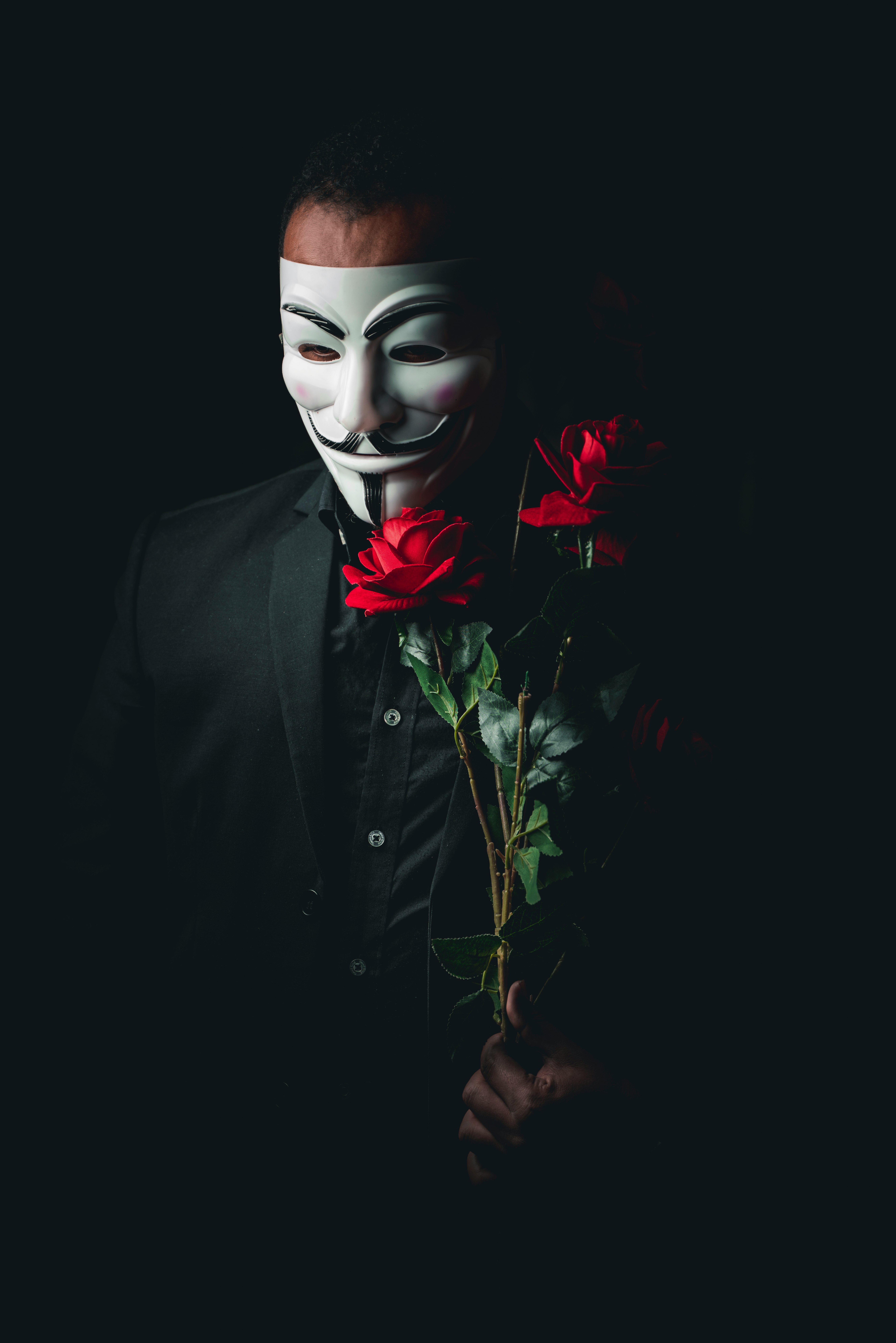 person in black suit with red rose on face
