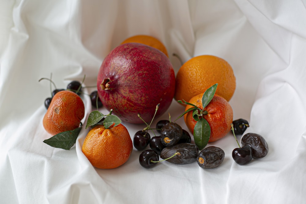 Fruta naranja y bayas negras sobre textil blanco