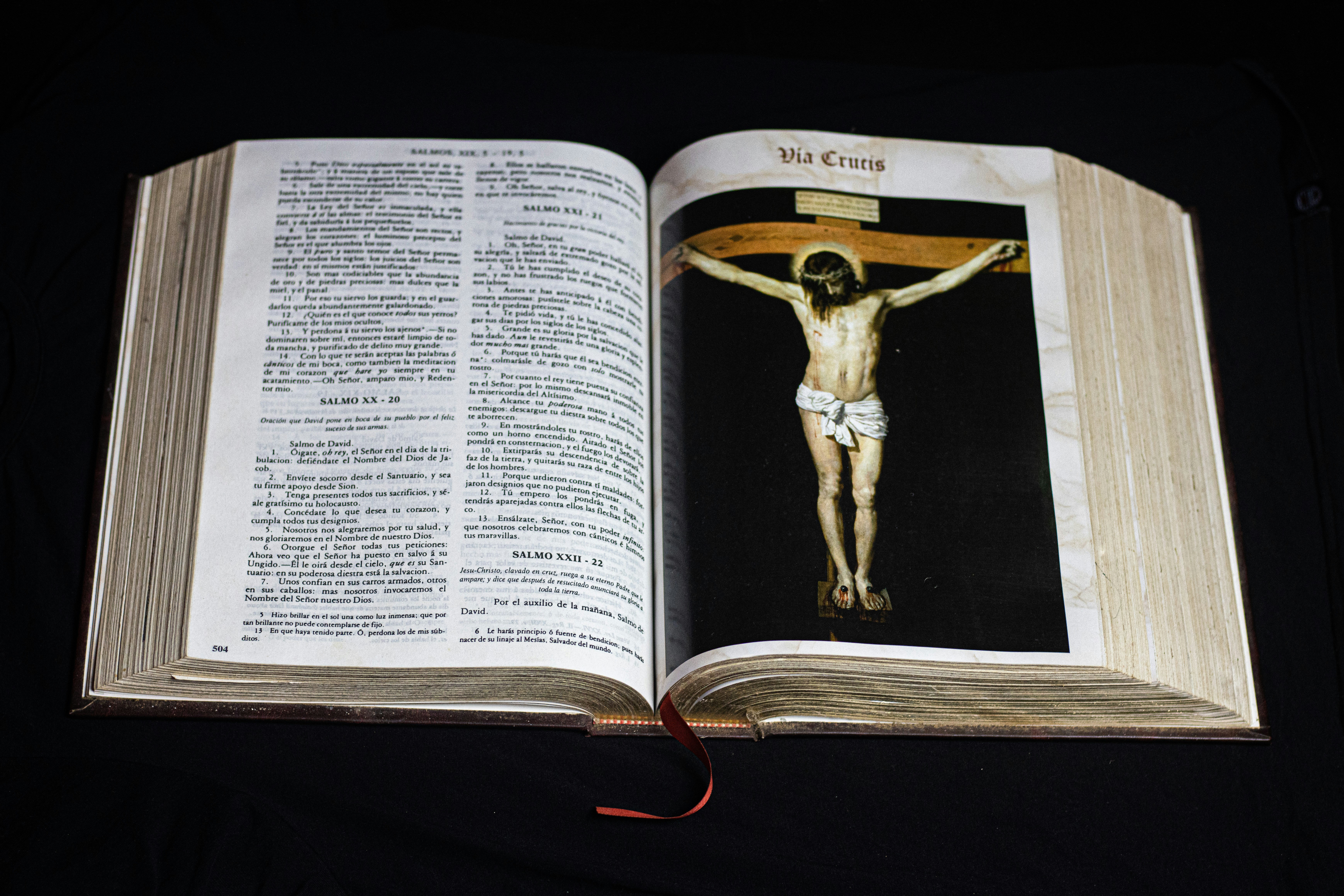 man in black pants and black shoes reading book