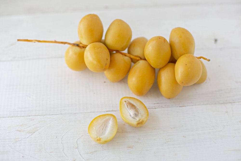 yellow round fruits on white wooden table