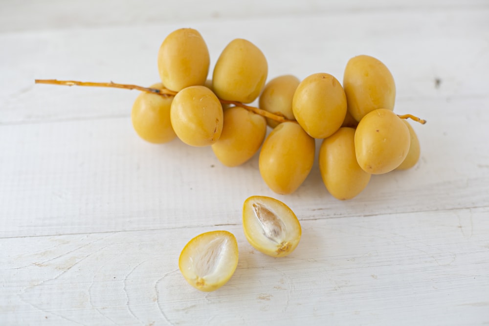 frutas redondas amarillas sobre una mesa de madera blanca