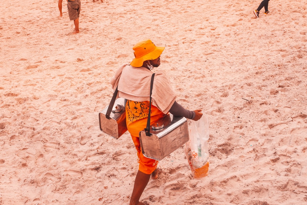 黄色と青のジャケットと青いデニムのショートパンツを着た女性が昼間のビーチを歩く