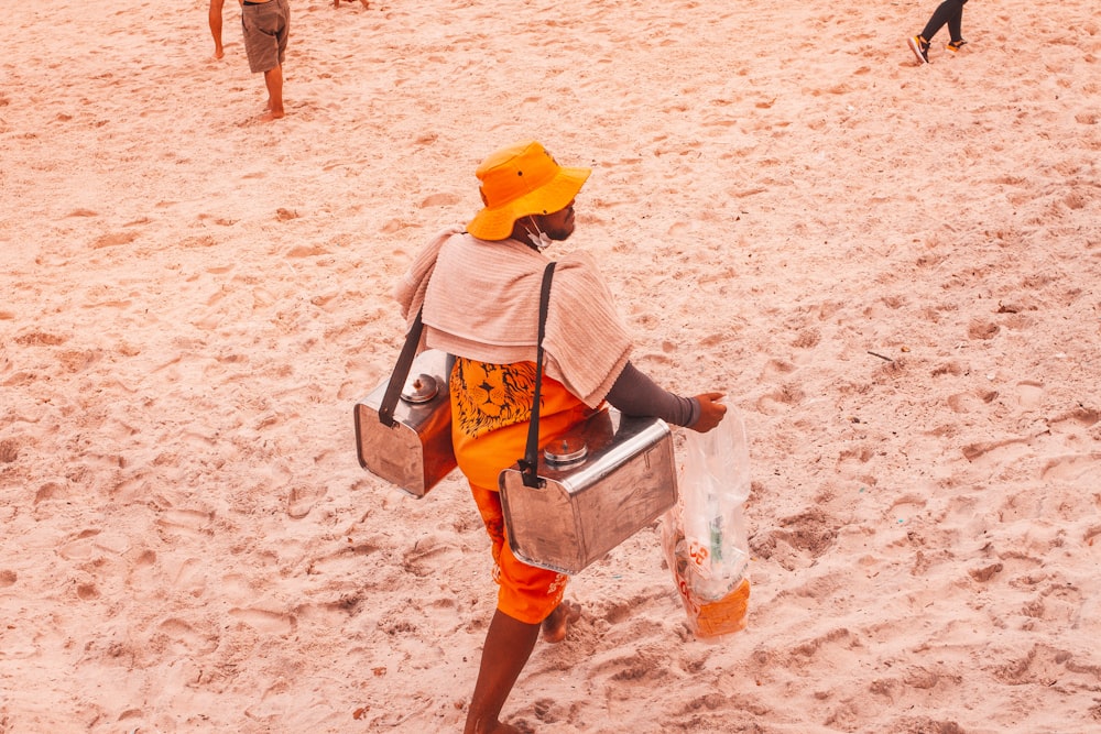 Frau in gelber und blauer Jacke und blauen Jeansshorts tagsüber am Strand spazieren