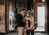 woman in black long sleeve shirt and brown pants standing beside woman in black long sleeve