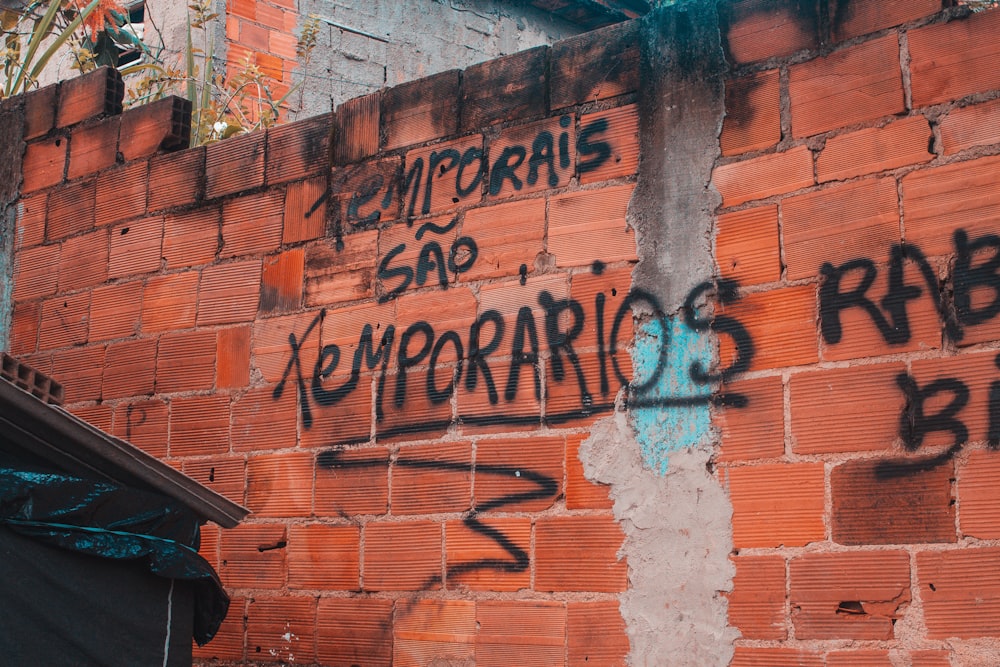 brown brick wall with graffiti