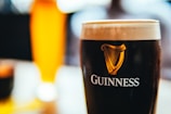a glass of beer sitting on top of a table