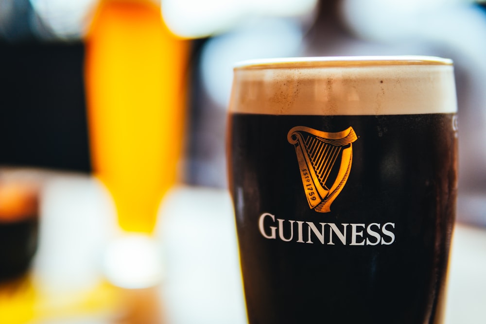 a glass of beer sitting on top of a table