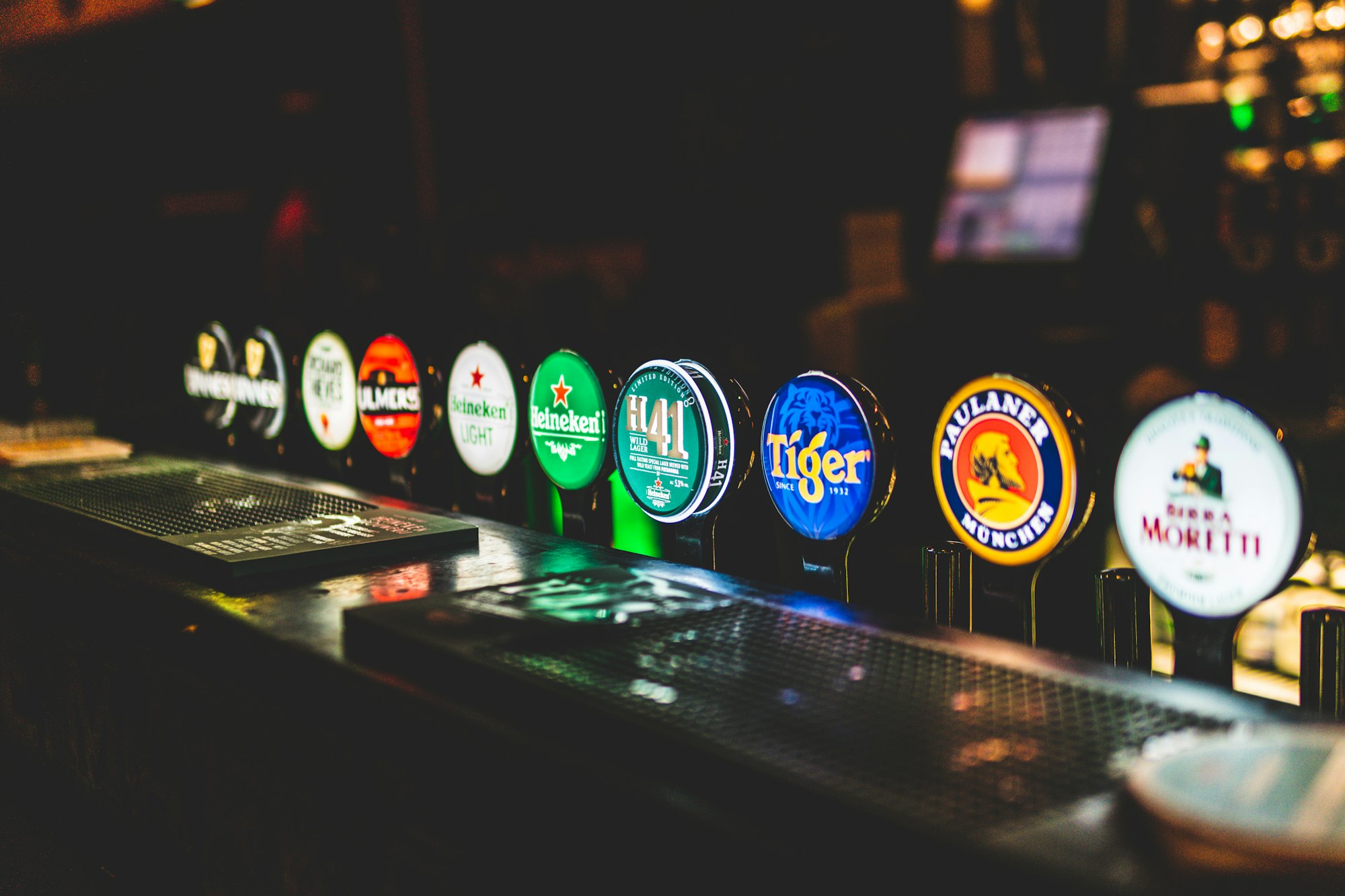 Different beer spouts in a bar that light up like an arcade machine.