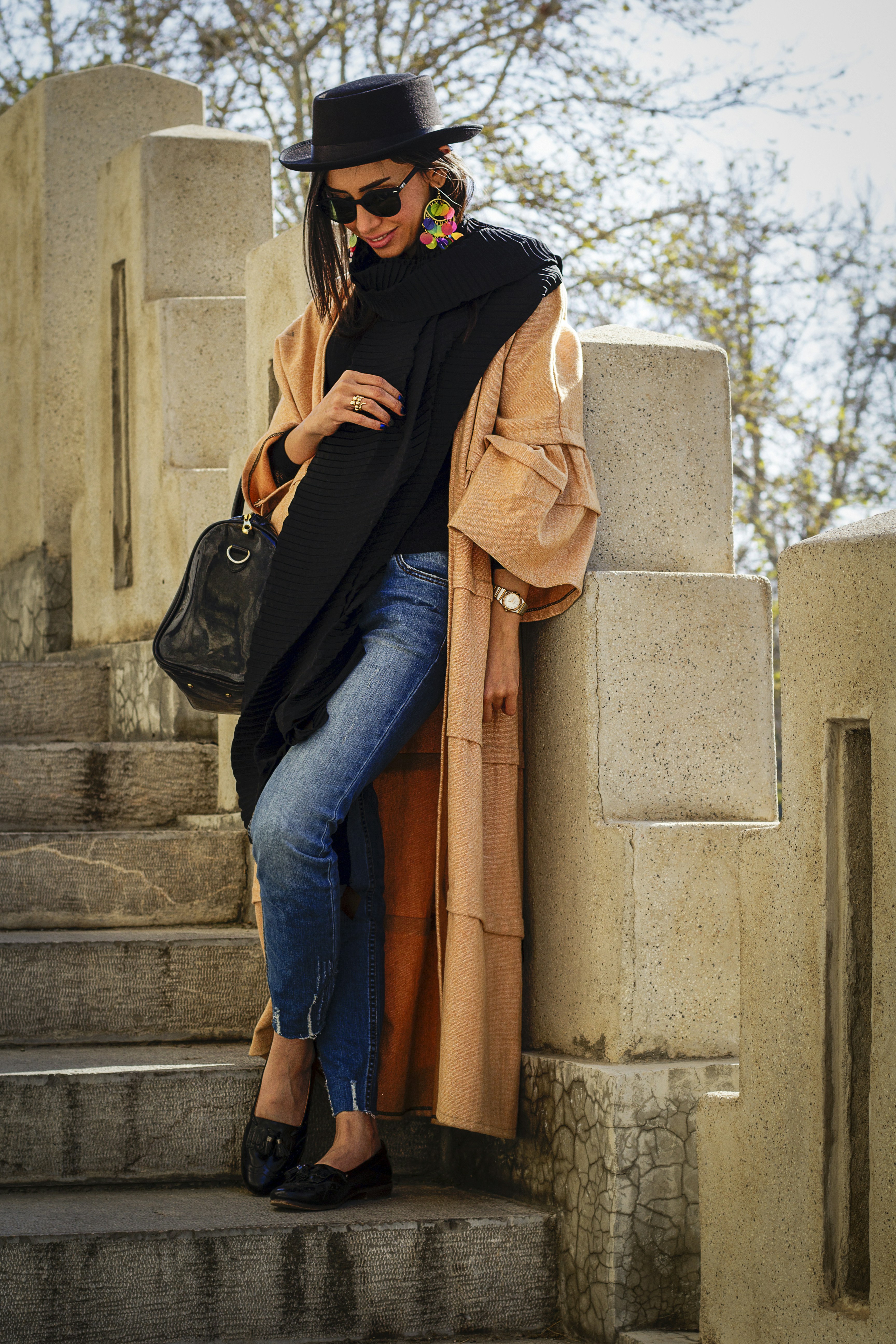 woman in black hijab and blue denim jeans sitting on concrete stairs