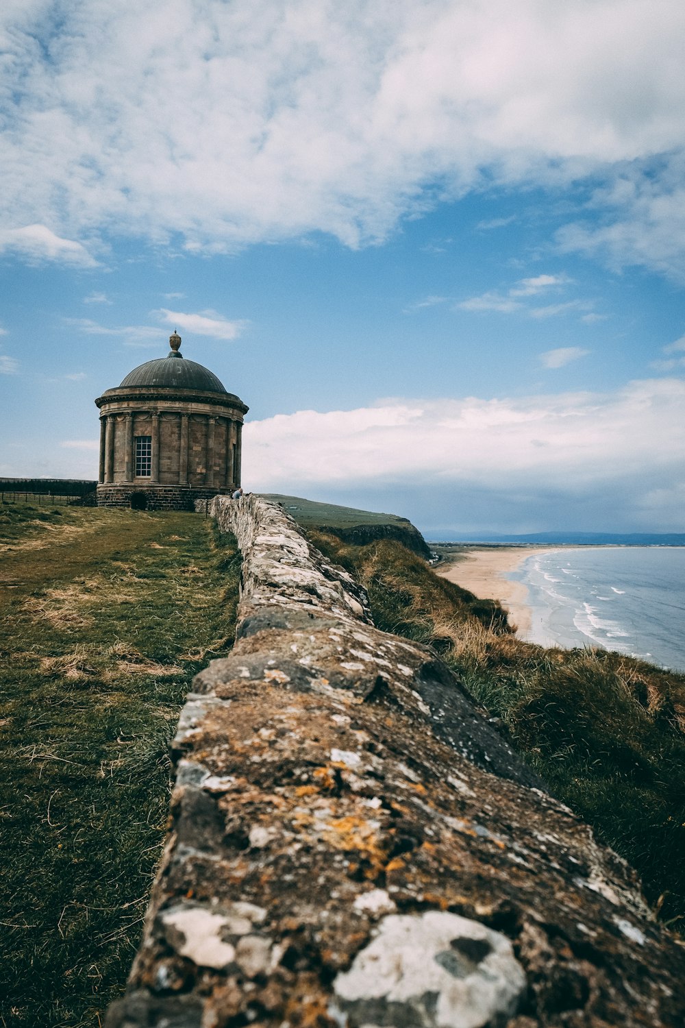 brown concrete building near sea under blue sky during daytime