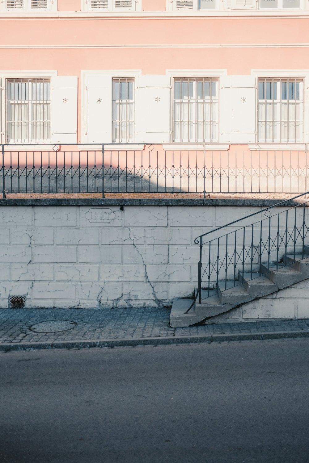 white concrete wall with black metal railings