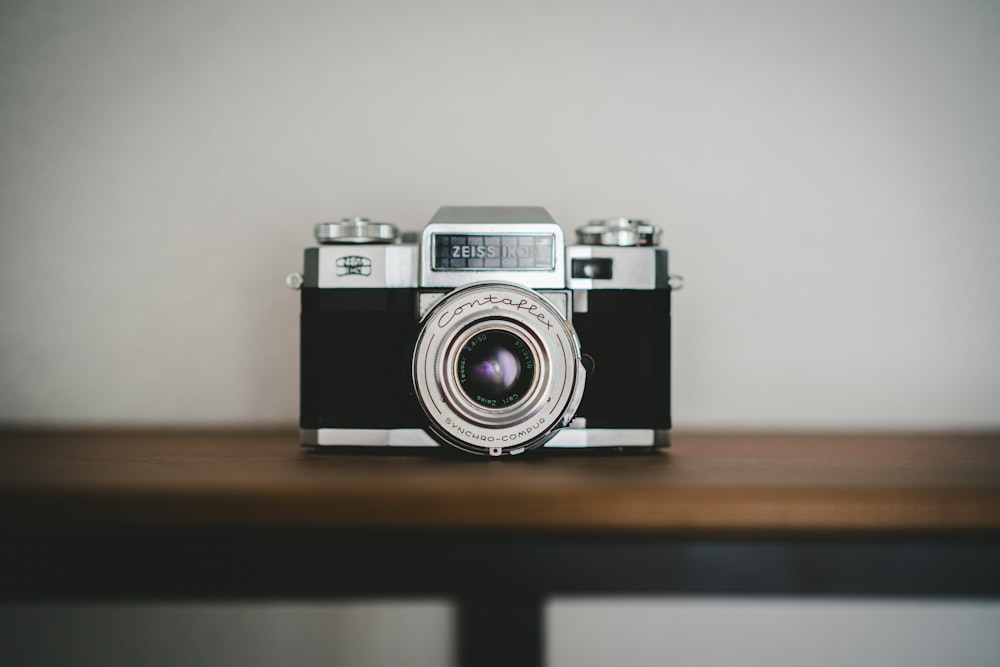 black and silver camera on brown wooden table