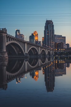 gray concrete bridge over body of water during night time