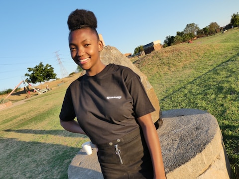 Technician inspecting playground equipment outdoors on a sunny day.