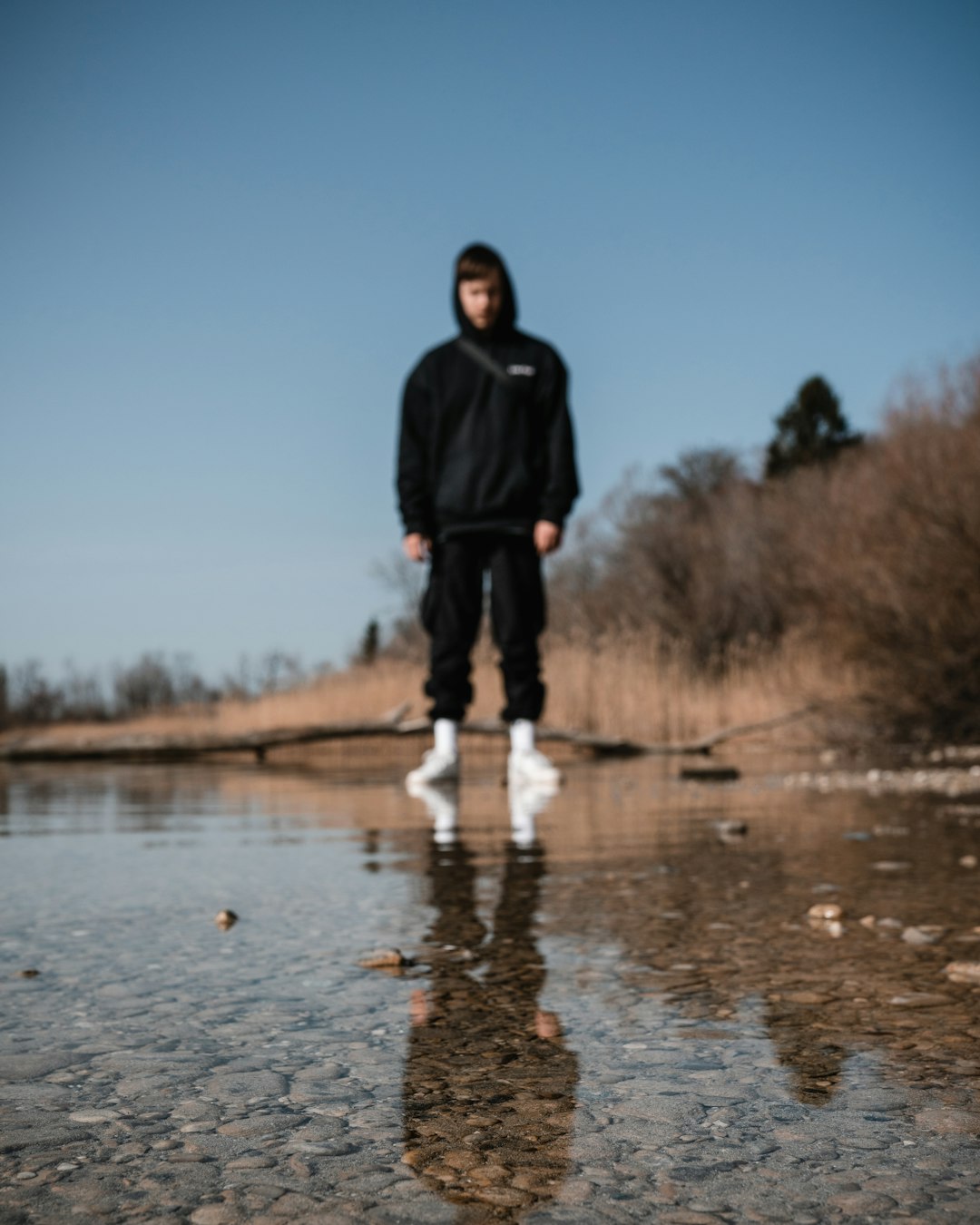 man in black jacket standing on water during daytime
