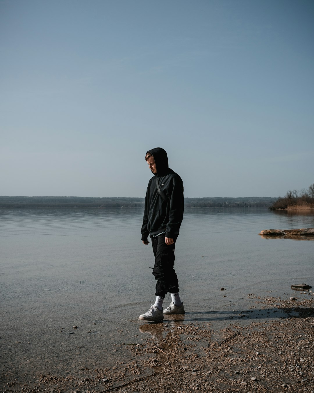 man in black jacket standing on seashore during daytime