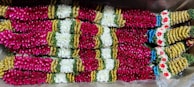 Readymade flower garlands hanging gracefully in a traditional wedding setting.