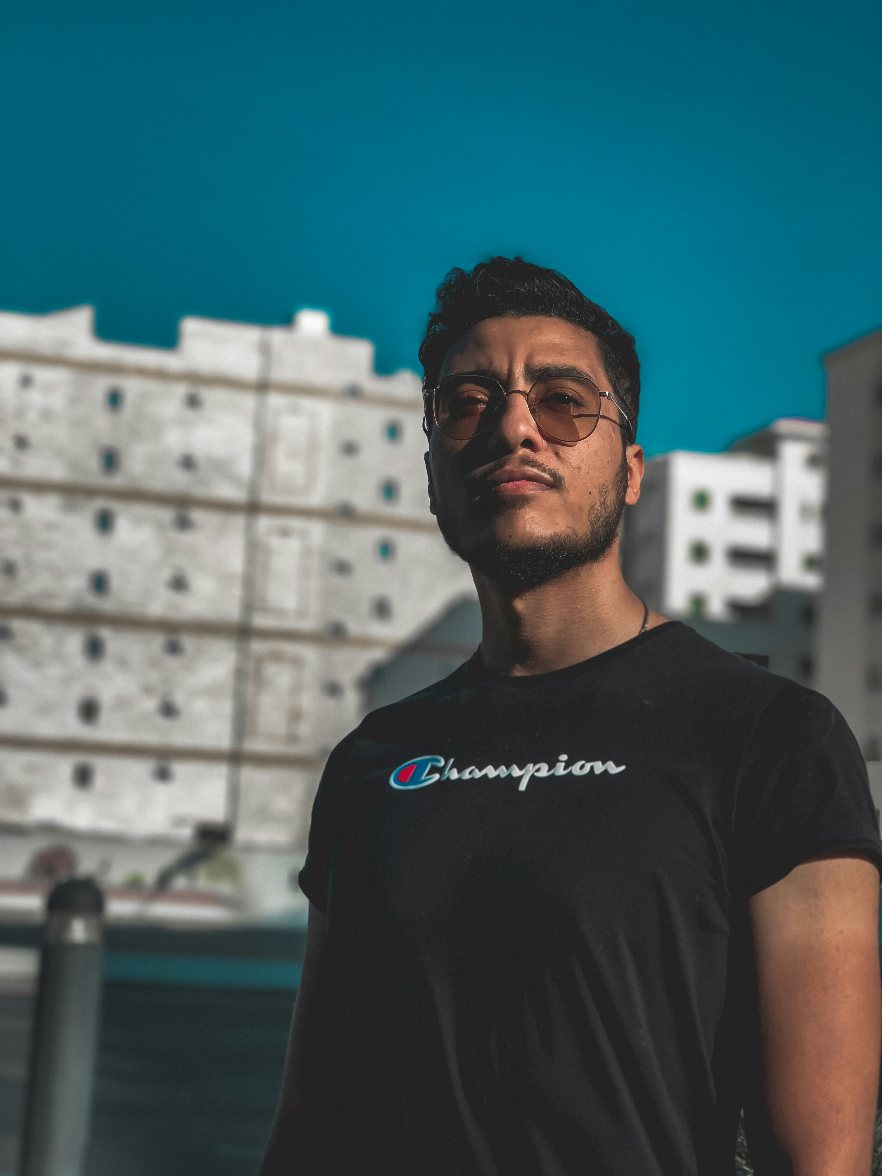 Indigo blue streetwear T-shirt on model outdoors in bright daylight with open sky