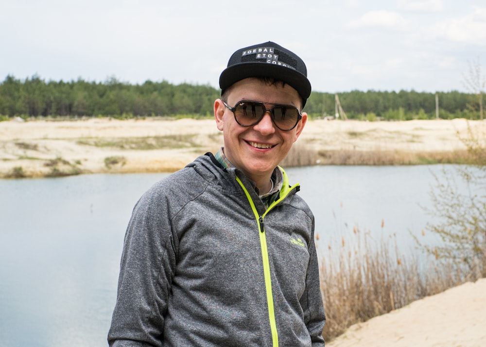 man in gray hoodie wearing black cap