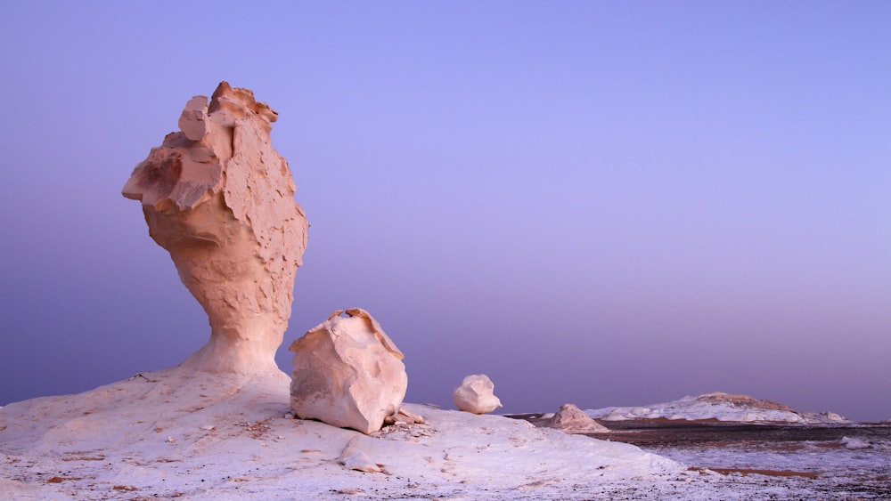 brown rock formation on white sand during daytime